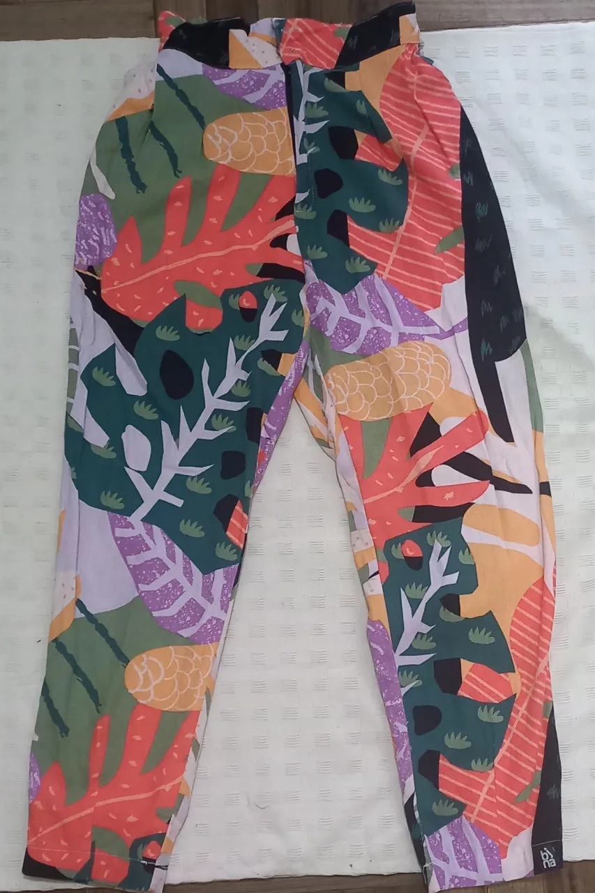Pantalón tipo Baggy estampado con motivos botánicos y abstractos en colores vibrantes. Cintura con elástico y dos botones metálicos. 