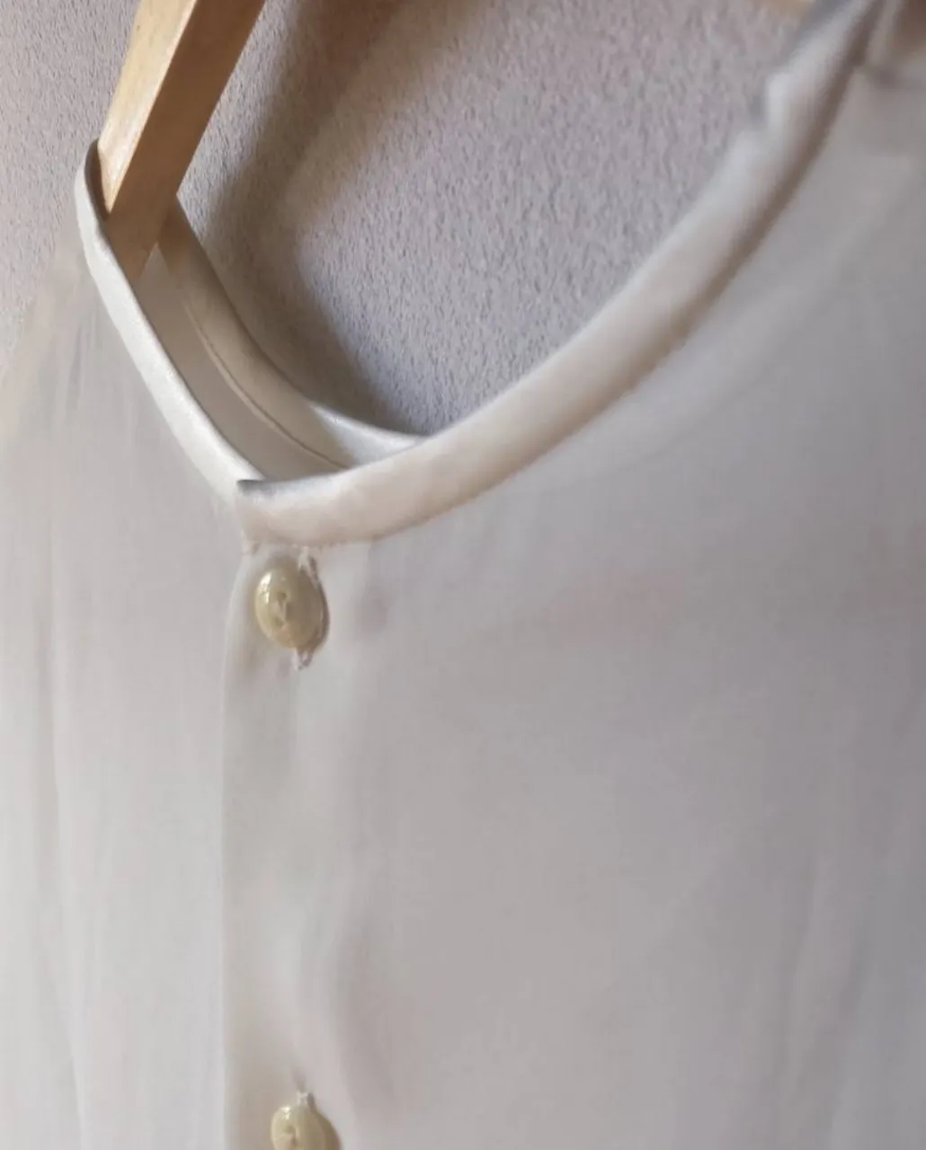 Blusa de seda con botones al frente y mangas cortas, color manteca
○ crudo. manga corta. talle 1
seria s grande o m chico. la tela
es transparente, super delicada
queda hermosa. La prenda está como
nueva. en todos sus contornos
tiene borde/vivo de raso. 
Cuello redondo.