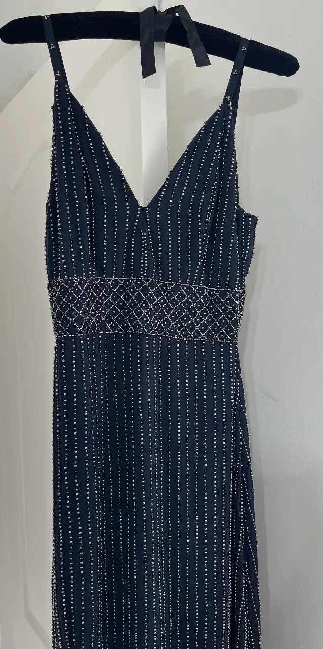 Vestido IMPORTADO largo de fiesta azul oscuro con detalles de brillos. Diseño italiano elegante con tirantes finos y escote en V. Cintura entallada con detalles brillantes y falda fluida con abertura lateral.