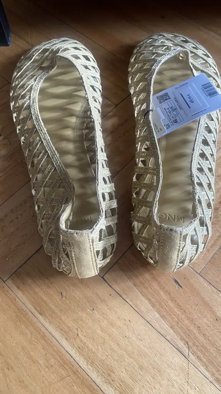 Sandalias planas doradas de la marca MNG, con diseño calado y etiqueta. Talle 40.
