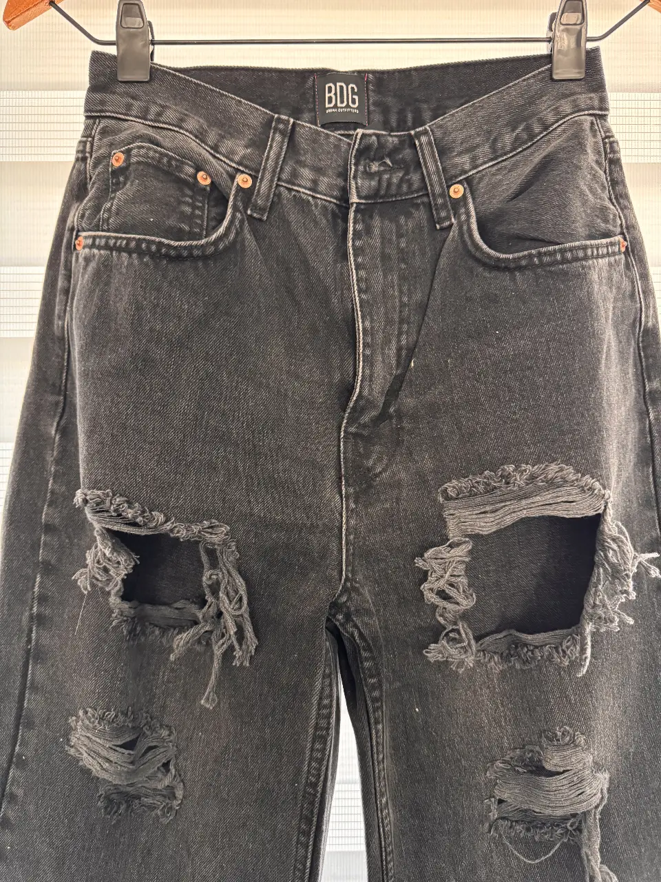 Jeans negro de tiro alto y corte baggy con roturas. Marca URBAN Outfiters BDG, talle 27. Ideal para un look casual y moderno.