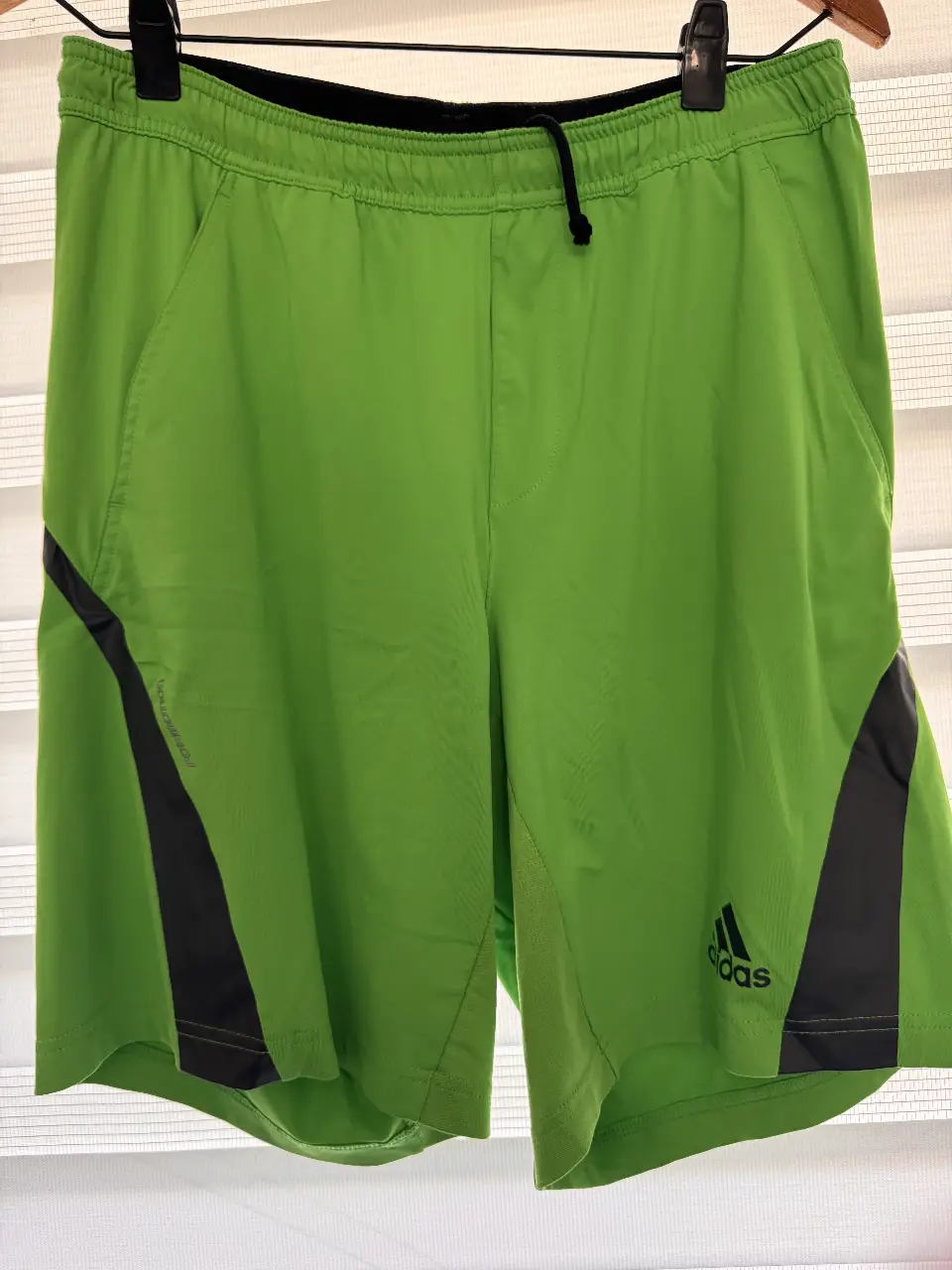 Short deportivo Adidas verde con detalles en gris y logo de la marca. Ideal para actividades físicas.