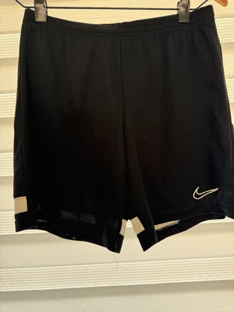 Short deportivo Nike Dri-Fit negro con detalles blancos. Ideal para entrenamientos y actividades físicas.