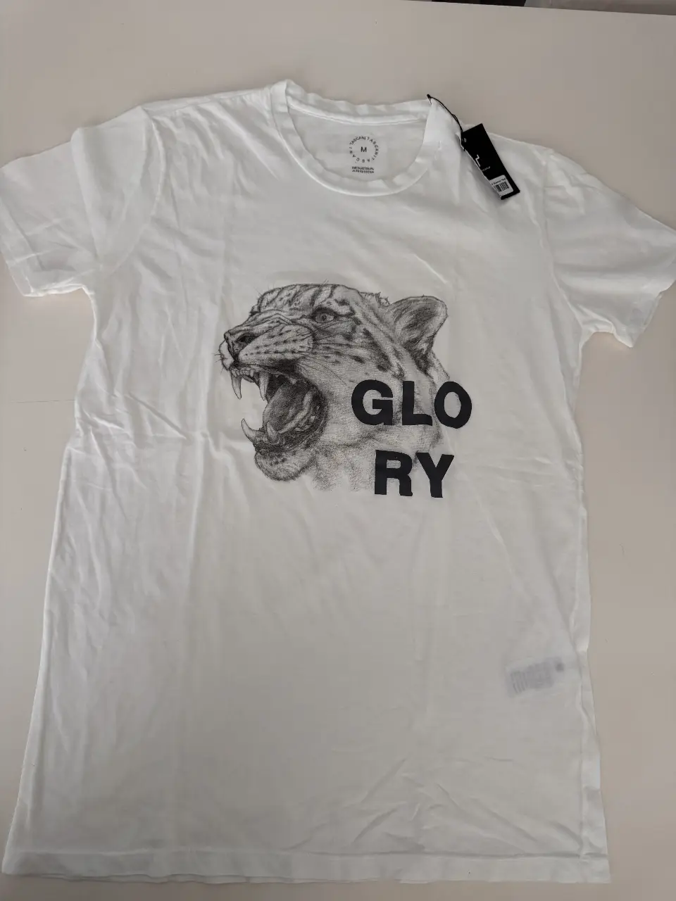 Remera blanca de hombre con estampado de un tigre y la palabra "GLORY". Ideal para un look casual y con onda.