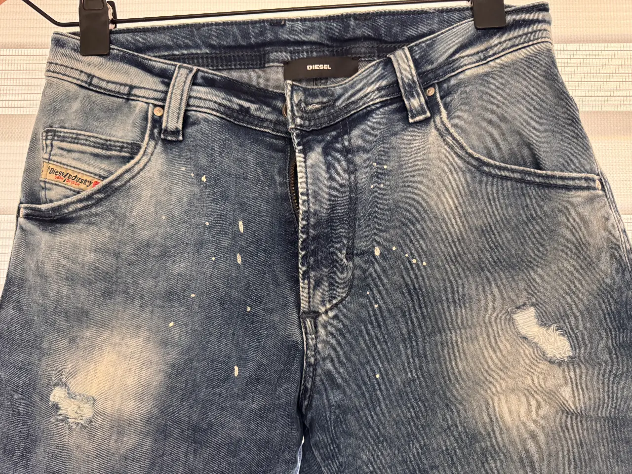 Short bermuda de jean Diesel azul para niños con detalles de roturas y manchas blancas. Talle 10.