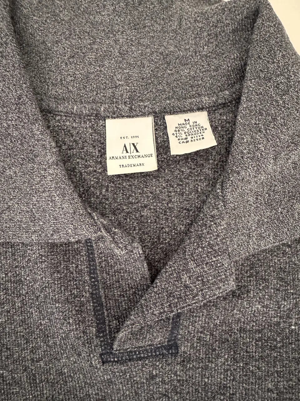 Remera tipo polo de hombre, de la marca Armani Exchange, color gris, con cuello y mangas cortas. Ideal para un look casual y cómodo.