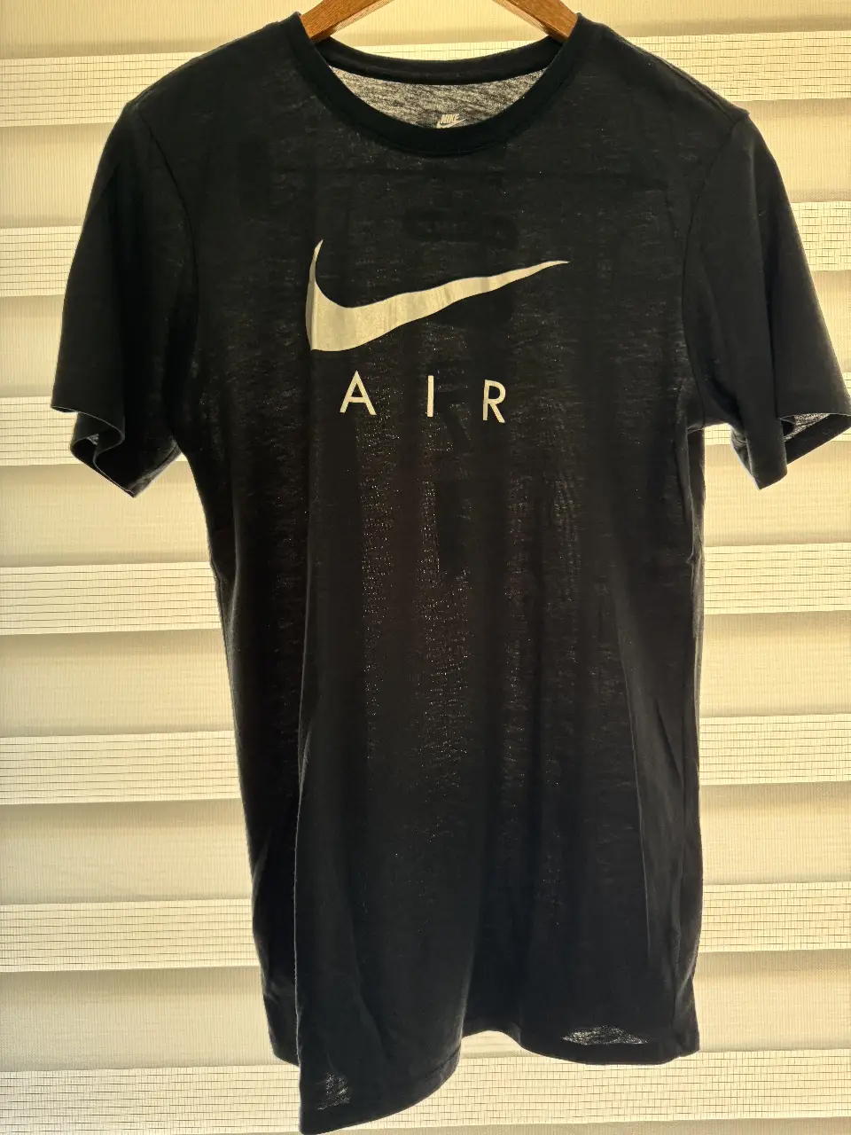 Remera Nike Air negra de hombre, con logo blanco en el frente y detalles en la espalda. Talle S, corte atlético, ideal para uso casual o deportivo.