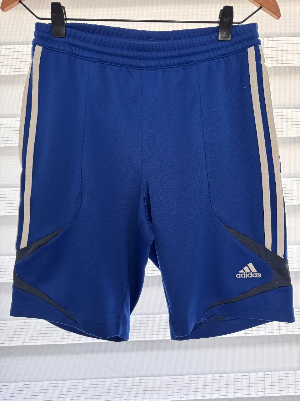 Short deportivo Adidas azul con detalles en blanco y negro. Ideal para entrenamientos y actividades físicas.