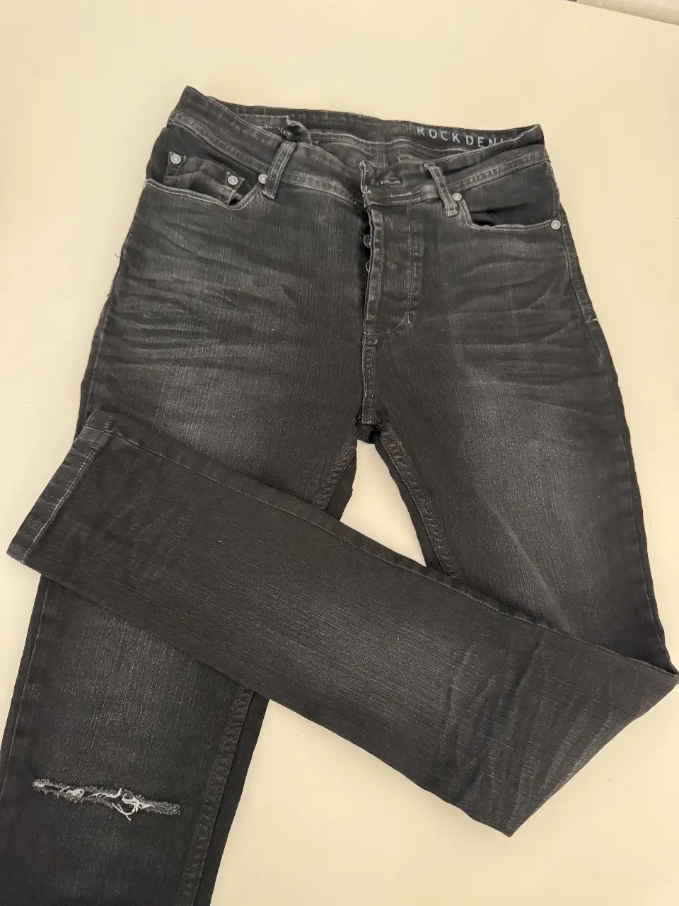 Jeans negro de hombre, corte recto, con roturas en la rodilla. Talle 30. Marca Key Biskayne