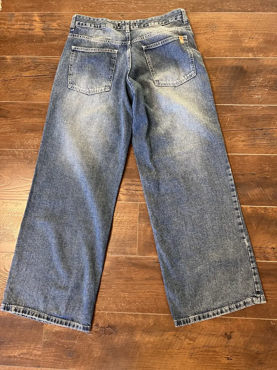 Jeans de mujer, corte wide leg, tiro medio, con detalles de desgaste. Talle 28.