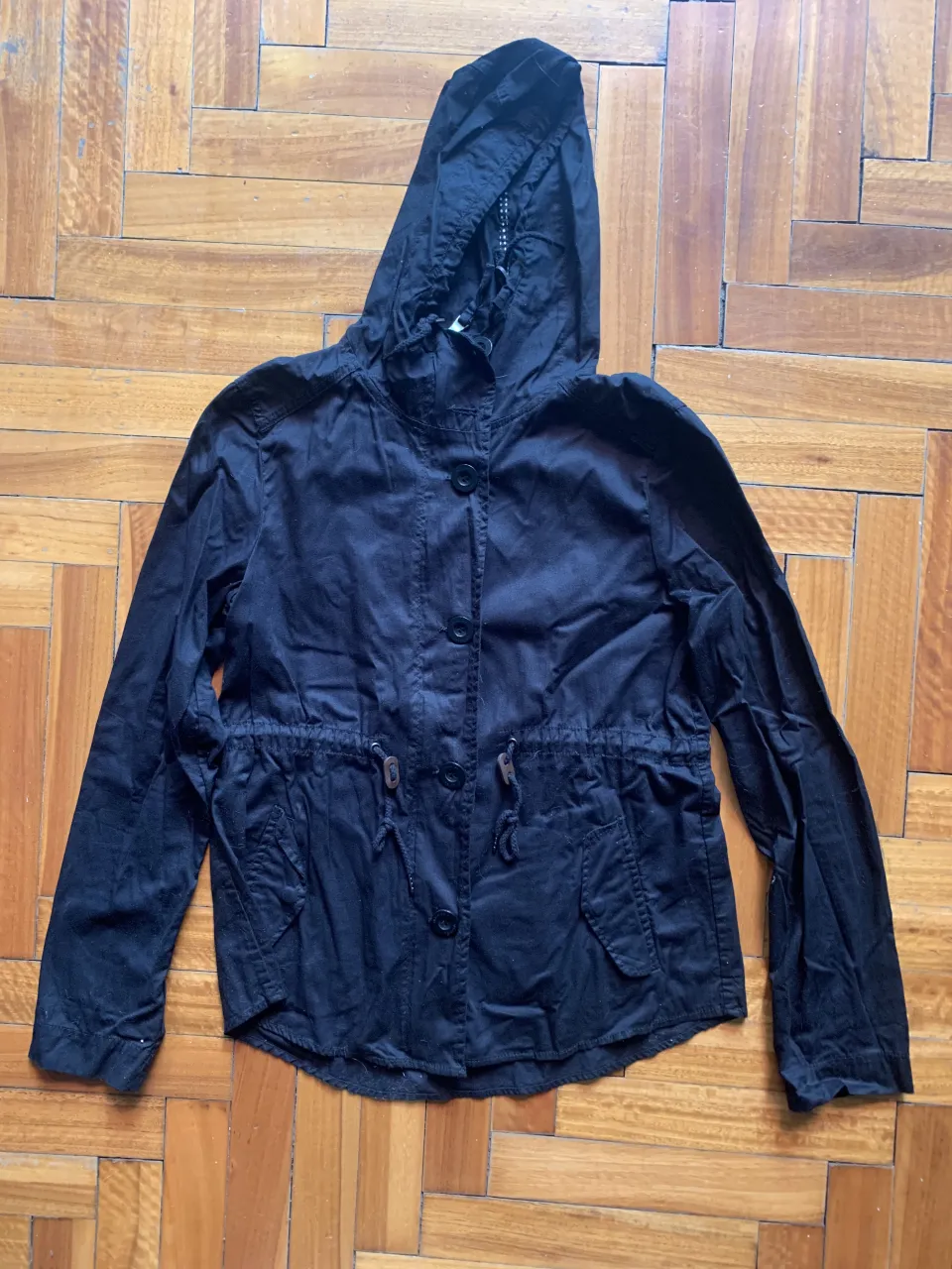 Campera negra con capucha y aplique de tigre en lentejuelas en la espalda. Tiene cordón ajustable en la cintura y botones al frente. Ideal para un look canchero y original. el aplique de lentejuelas también se lo podrías descoser. importada una tela hermosa 