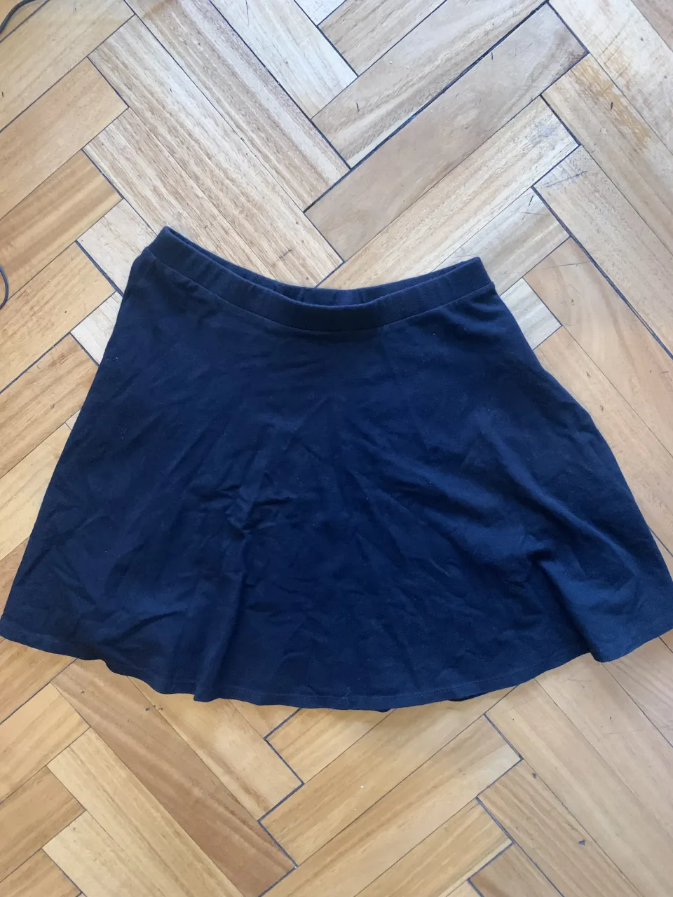 Pollera negra corta, ideal para cualquier ocasión. Su diseño versátil la hace perfecta para combinar con diferentes tops y calzado, creando looks tanto casuales como más arreglados. ¡Un básico indispensable en tu guardarropa!