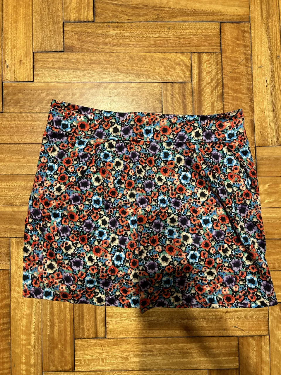 Pollera corta estampada con flores. Tiene cierre en la parte trasera.