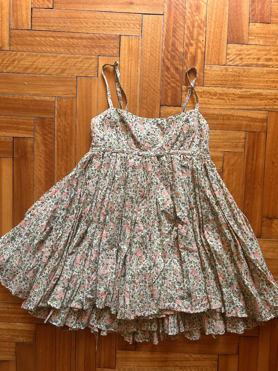 Vestido mini floreado con tirantes finos, ideal para el verano. Diseño con detalles de volantes y un corte que favorece la figura. Perfecto para un look fresco y femenino.