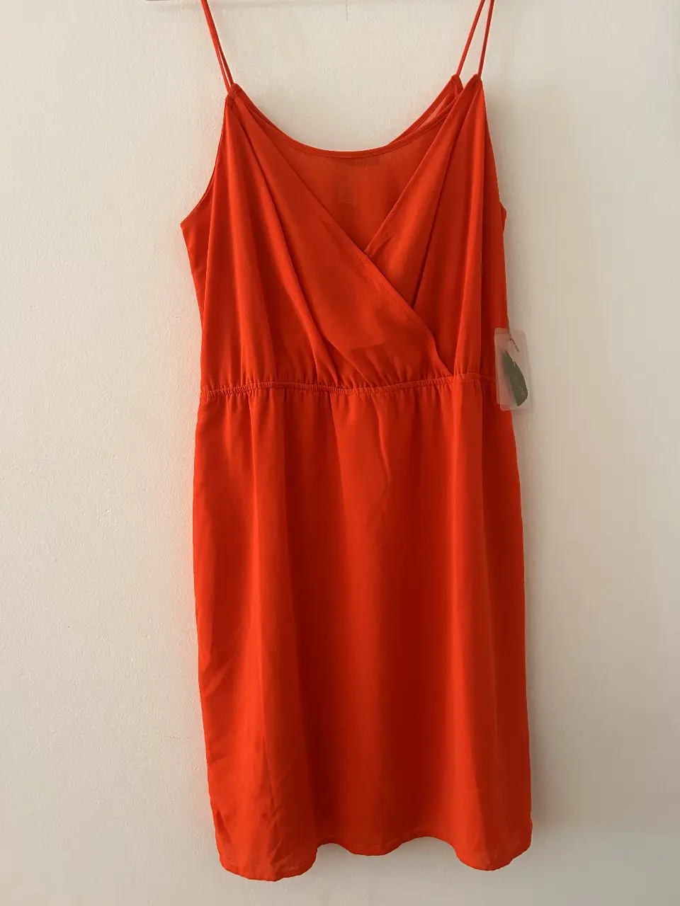 Vestido mini naranja con tiras finas y detalle drapeado en el busto. Ideal para el verano, fresco y cómodo.