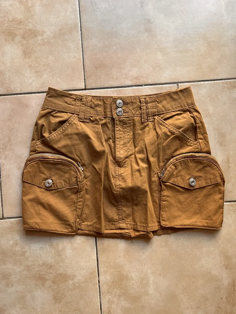 Minifalda de gabardina color marrón con bolsillos cargo y detalles de botones. Ideal para un look Y2K y utilitario.