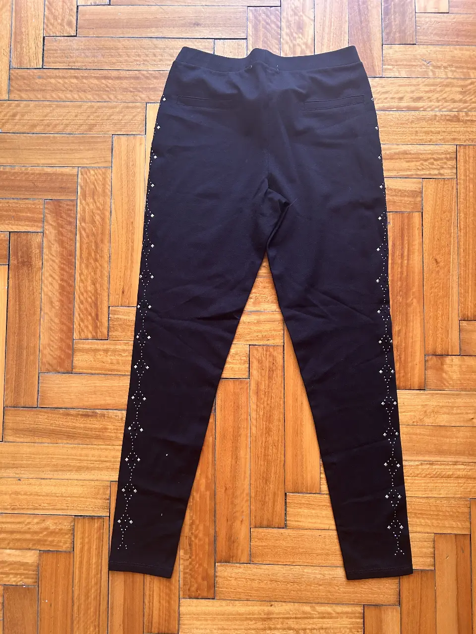 calza negro de vestir con detalles de strass en los laterales. Tiro medio, corte recto y calce perfecto. Ideal para un look elegante y sofisticado.