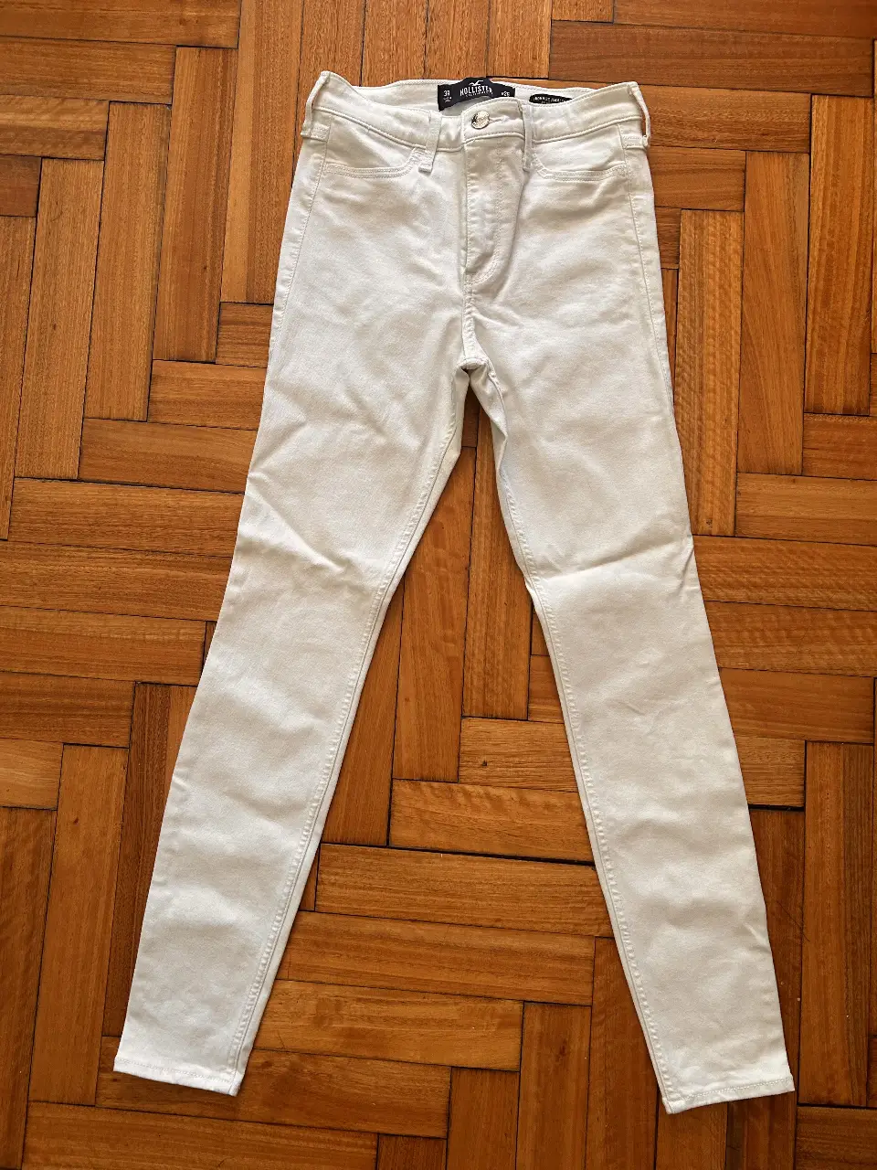 Jeans Hollister tiro alto, color blanco, talle 26x28, estilo "High Rise Jean Legging". Ideal para un look casual y moderno.