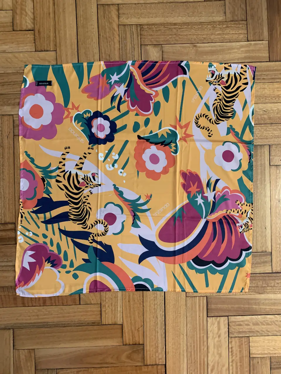 Pañuelo Shibinda con estampado floral y de tigres. Ideal para darle un toque de color y estilo a cualquier look. Perfecto para usar en la cabeza, cuello o como accesorio en tu cartera.