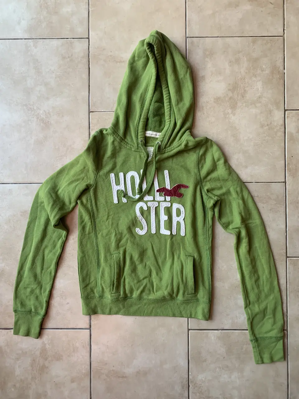 Buzo canguro Hollister verde, con capucha y bolsillo frontal. Talle M, ideal para un look casual y cómodo.
