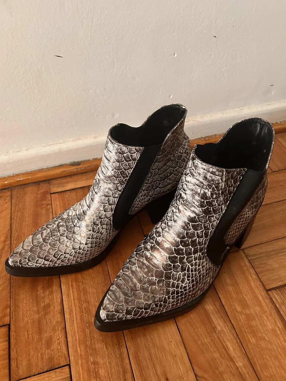Botines de mujer con estampado de serpiente. Tienen un diseño moderno y elegante, con un tacón ancho y cómodo. Ideales para cualquier ocasión.