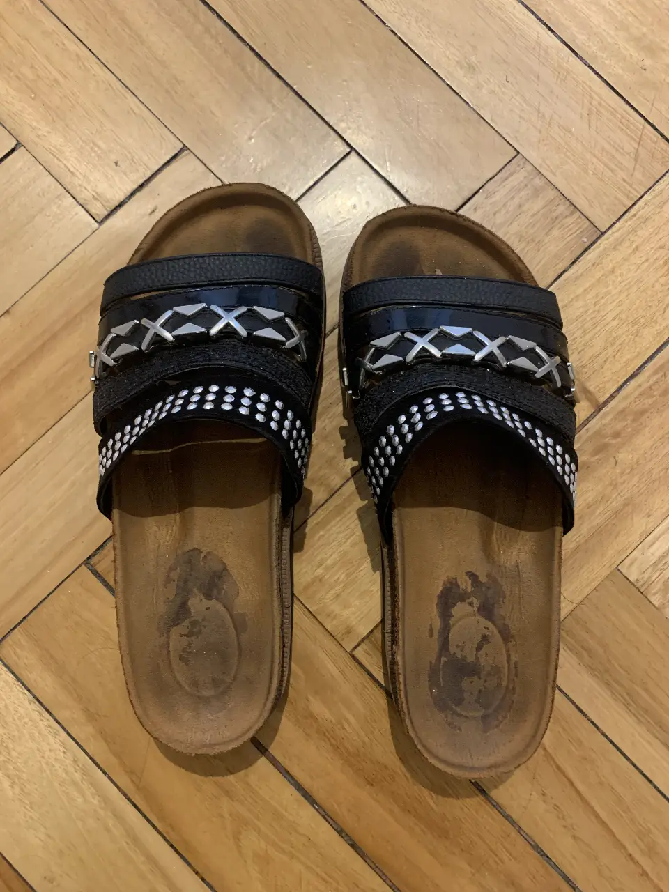 Sandalias  negras con detalles plateados. Ideales para un look casual y cómodo en verano. Su diseño incluye tiras decorativas y una suela resistente.