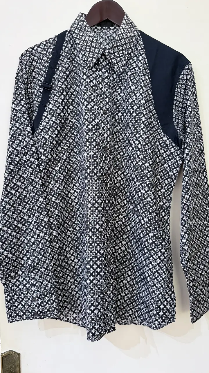Harness Camisa estampada de hombre, manga larga, con diseño geométrico en blanco y negro. Detalles en negro en los hombros y cuello. Ideal para un look casual o semi-formal.
