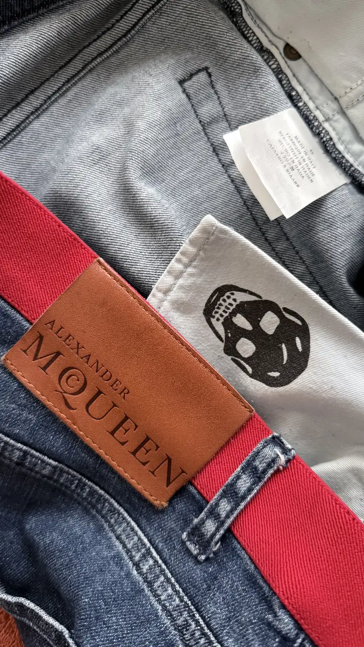 Jeans rectos de hombre Alexander McQueen con detalle de cintura roja y etiqueta de cuero con el logo de la marca. Un clásico atemporal para un look casual y moderno.