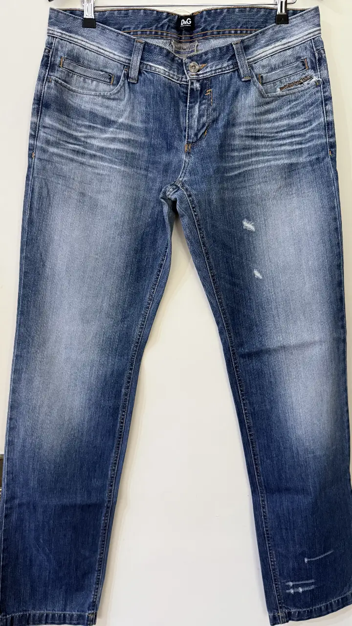 Jeans rectos de hombre, color azul gastado, con detalles de roturas y desgaste. Marca D&G.