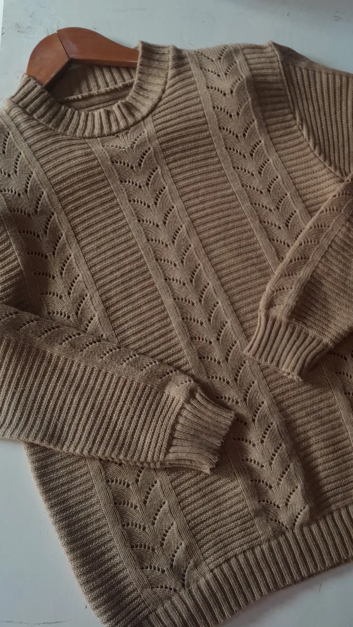 Sweater de punto para mujer, color crudo, con diseño calado y detalles acanalados. Ideal para un look casual y abrigado.