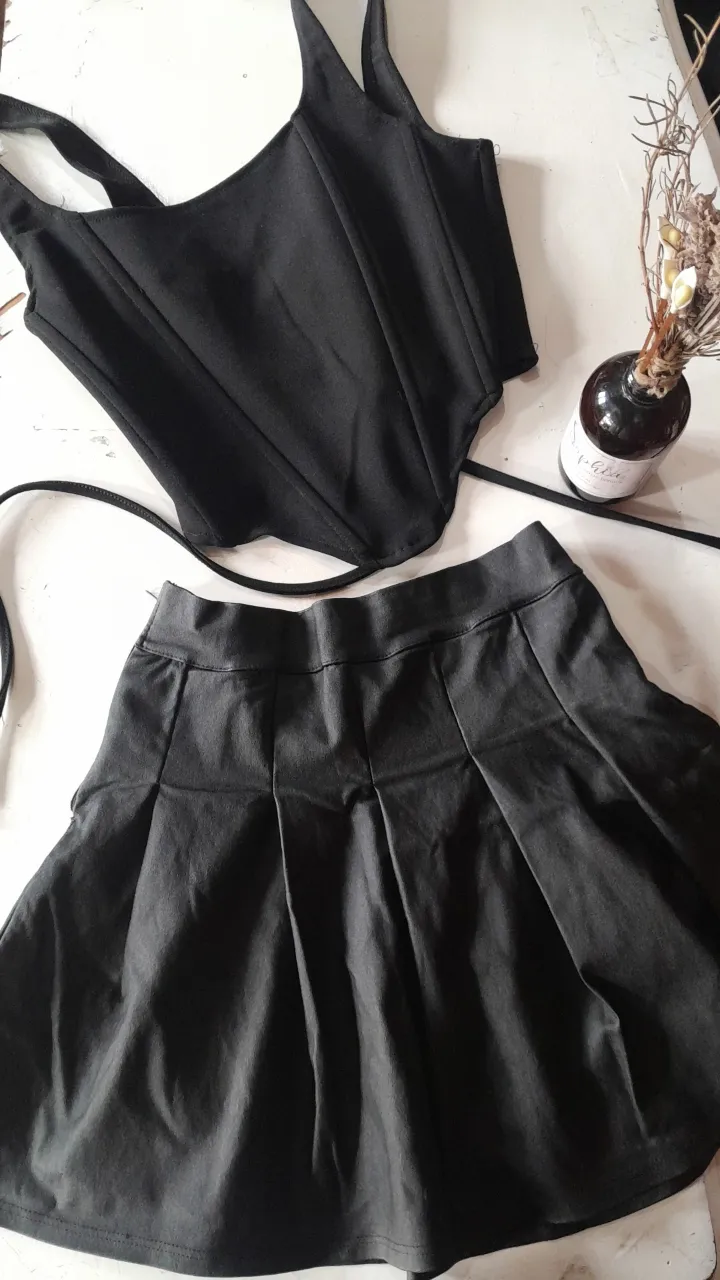 Conjunto de top corset y pollera tableada en color negro. Ideal para un look gótico o alternativo. Perfecto para salidas nocturnas o eventos especiales.