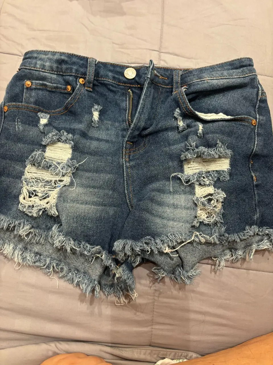 Short de jean azul con roturas y flecos en el borde. Tiro medio, ideal para un look casual y canchero. talle 3
