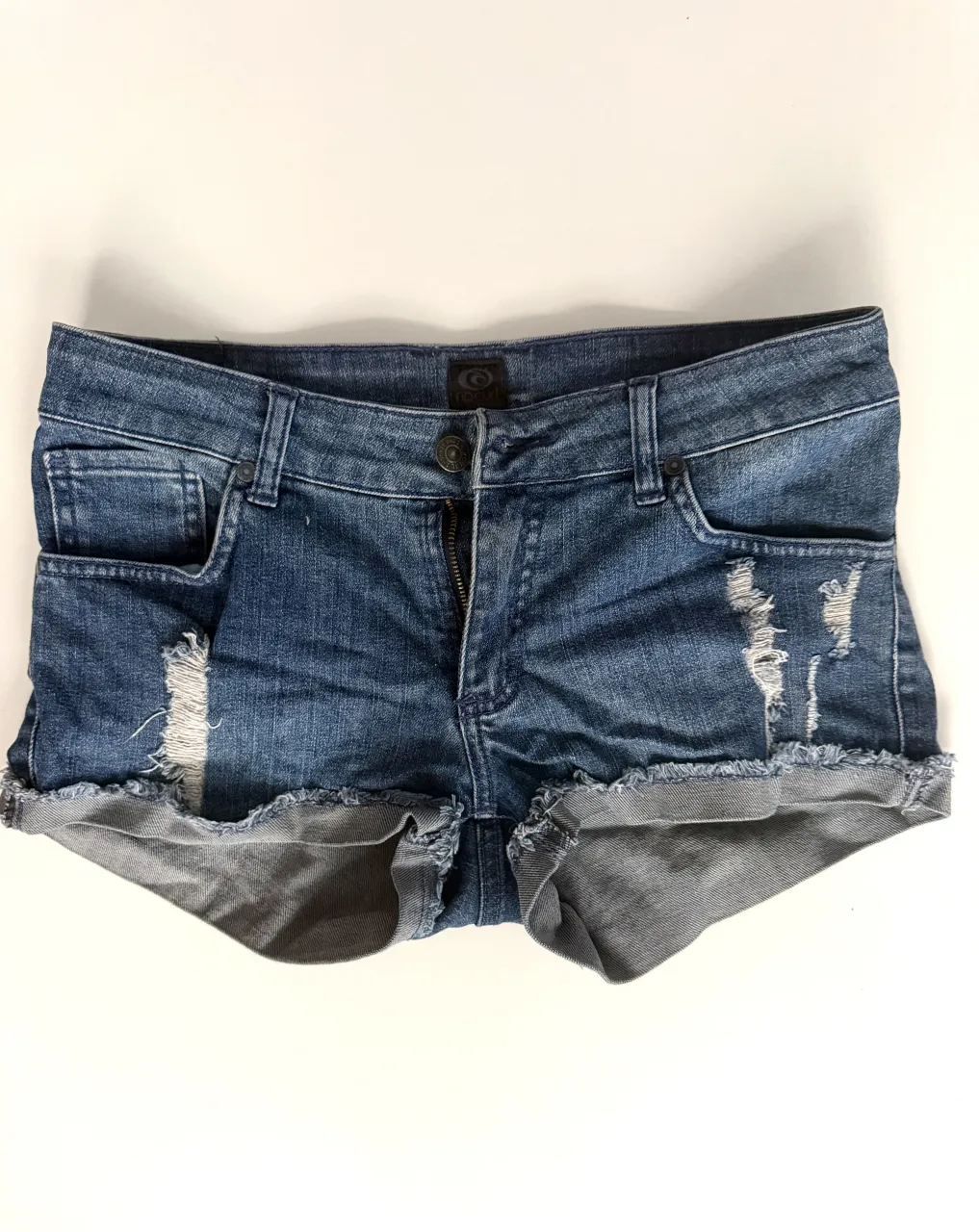 Shorts de jean tiro medio bajo con roturas y dobladillo desflecado. Un clásico para el verano, perfectos para un look casual y descontracturado.
