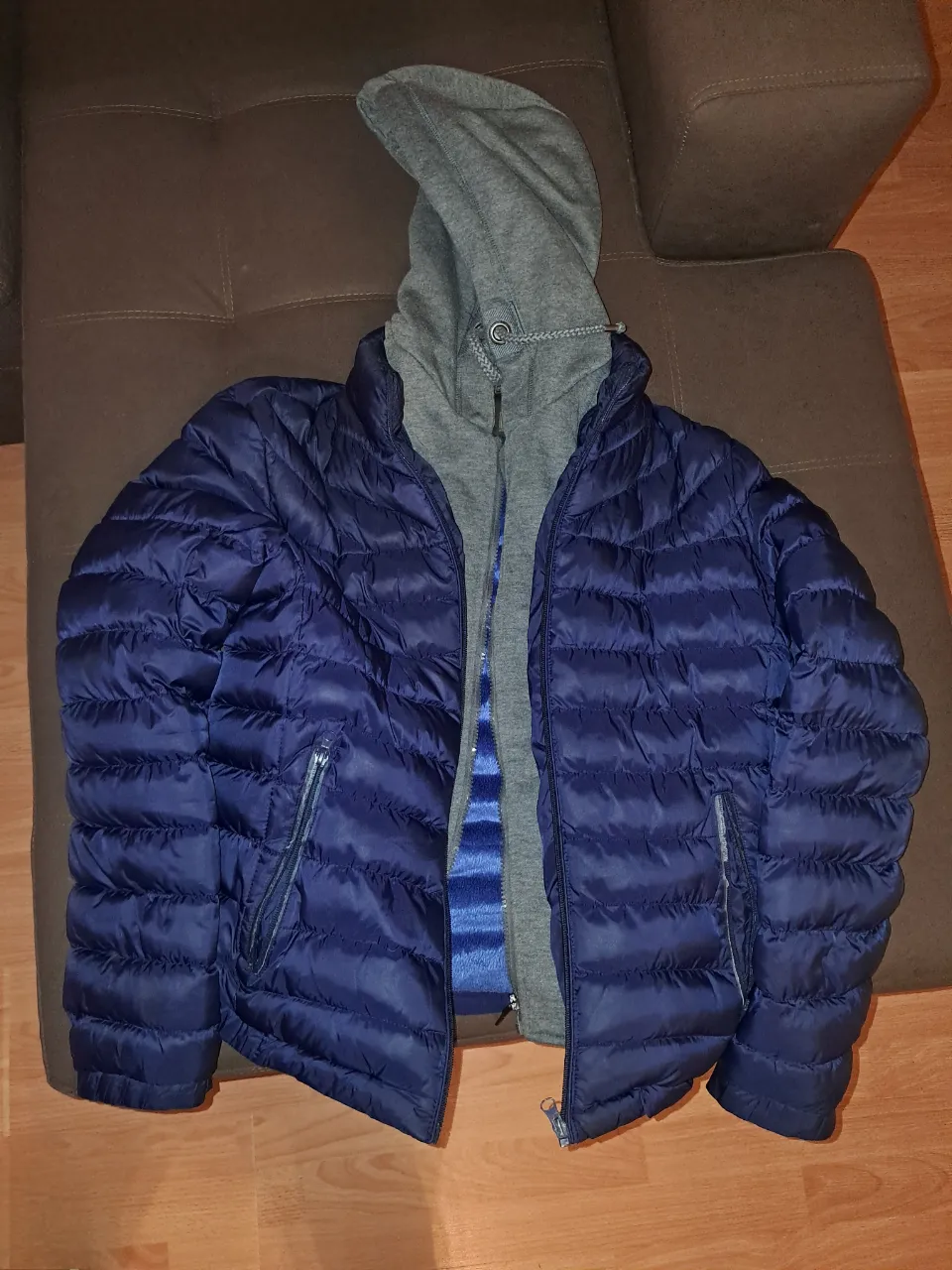 Campera de pluma azul marino con capucha gris. Ideal para el invierno, abrigada y cómoda. Perfecta para un look casual y urbano. Talle M