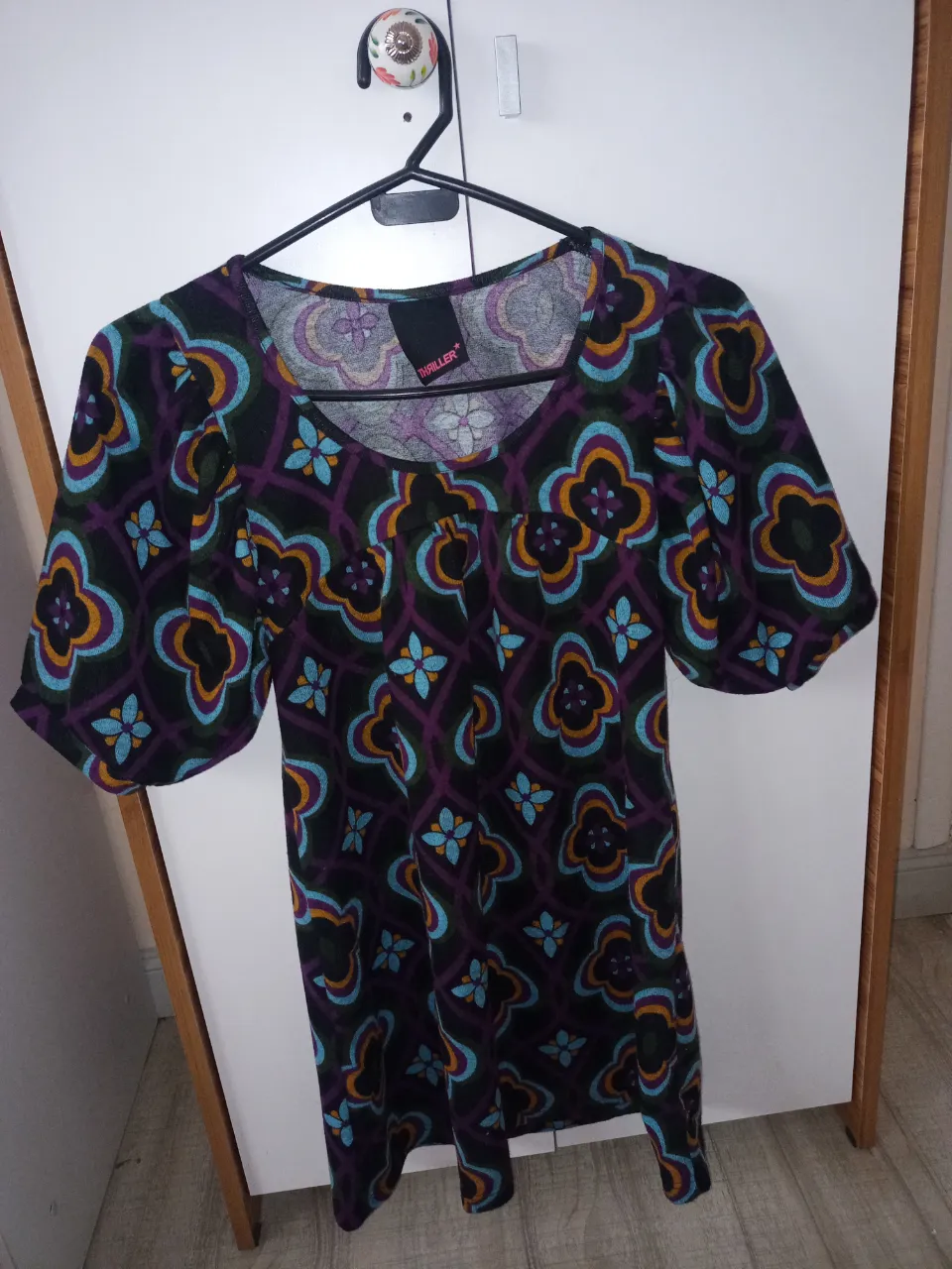 Vestido de lanilla corto con mangas globo al codo y estampado geométrico en tonos morado, azul, naranja y negro. 