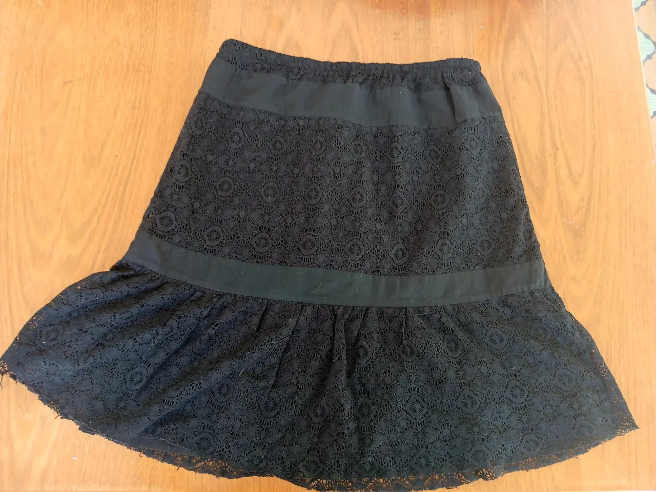 Pollera negra de encaje con volado en la parte inferior. Posee una banda de tela lisa en la cintura y otra a la altura de la rodilla. Largo apenas debajo de la rodilla. Con elástico grueso en la cintura para más comodidad. A un super precio!