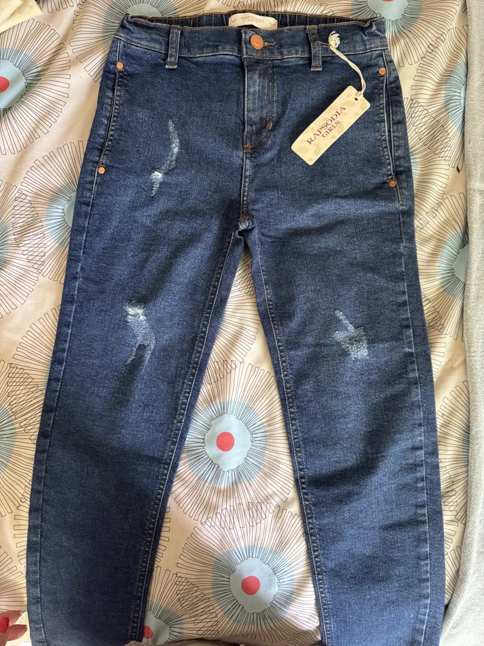 Jean de tiro alto con roturas y detalles desgastados. Un clásico moderno para tu día a día.