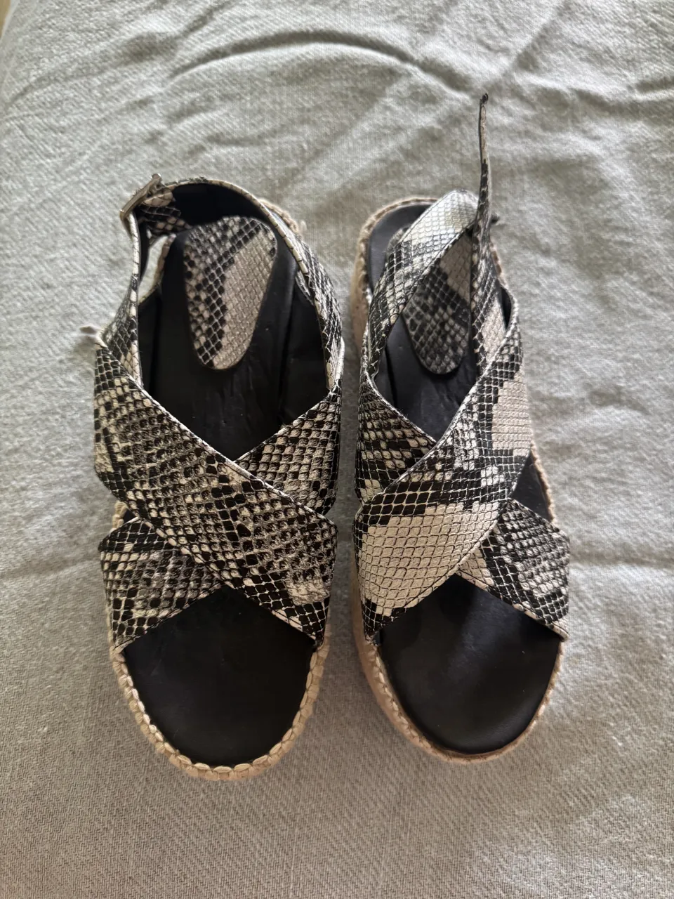 Sandalias de plataforma con diseño de serpiente. Tienen tiras cruzadas y hebilla para ajustar. Ideales para un look canchero y moderno.