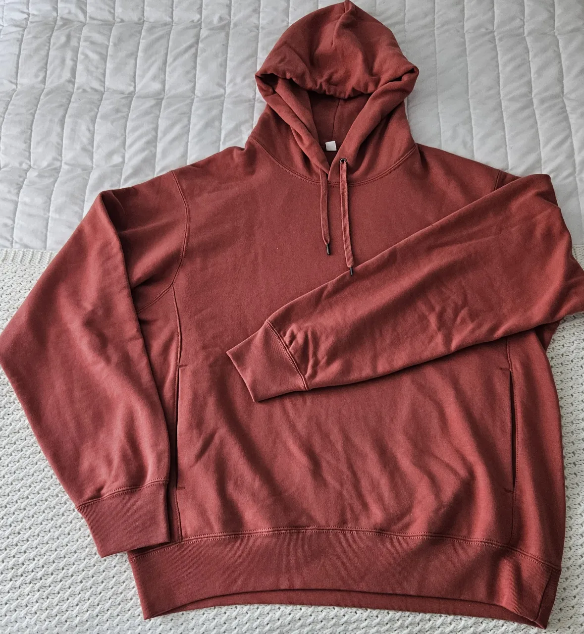 Buzo Uniqlo Unisex con capucha, bolsillos y cordones. Ideal para un look casual y cómodo. Nuevo sin etiqueta. 