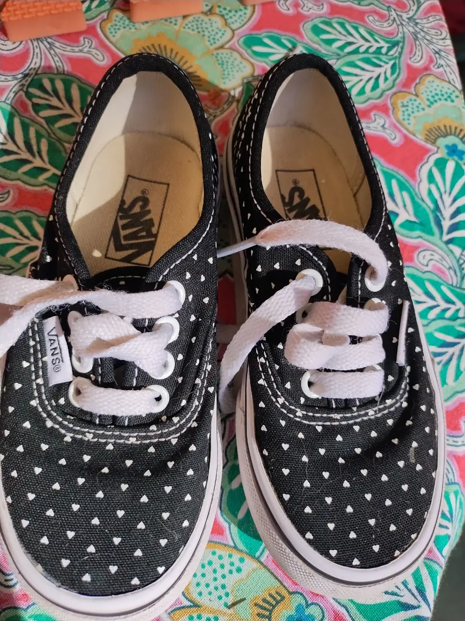 Zapatillas Vans negras con lunares blancos, ideales para un look casual y urbano. Su diseño clásico y versátil las convierte en un calzado perfecto para cualquier ocasión.
