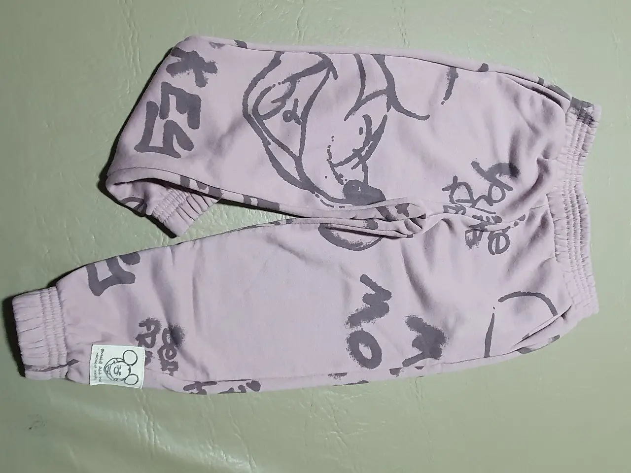 Pantalón de niña, de color rosa con estampado. Con cintura elastizada y puños en los tobillos. Estampado de dibujos animados. Marca Disney.