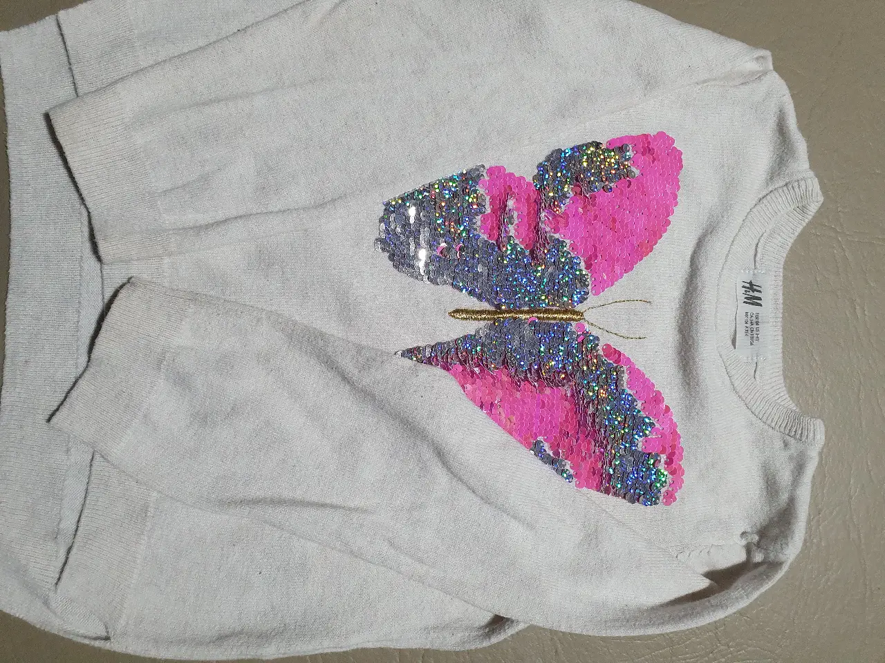 Sweater de niña con diseño de mariposa con lentejuelas. Ideal para un look casual y abrigado.