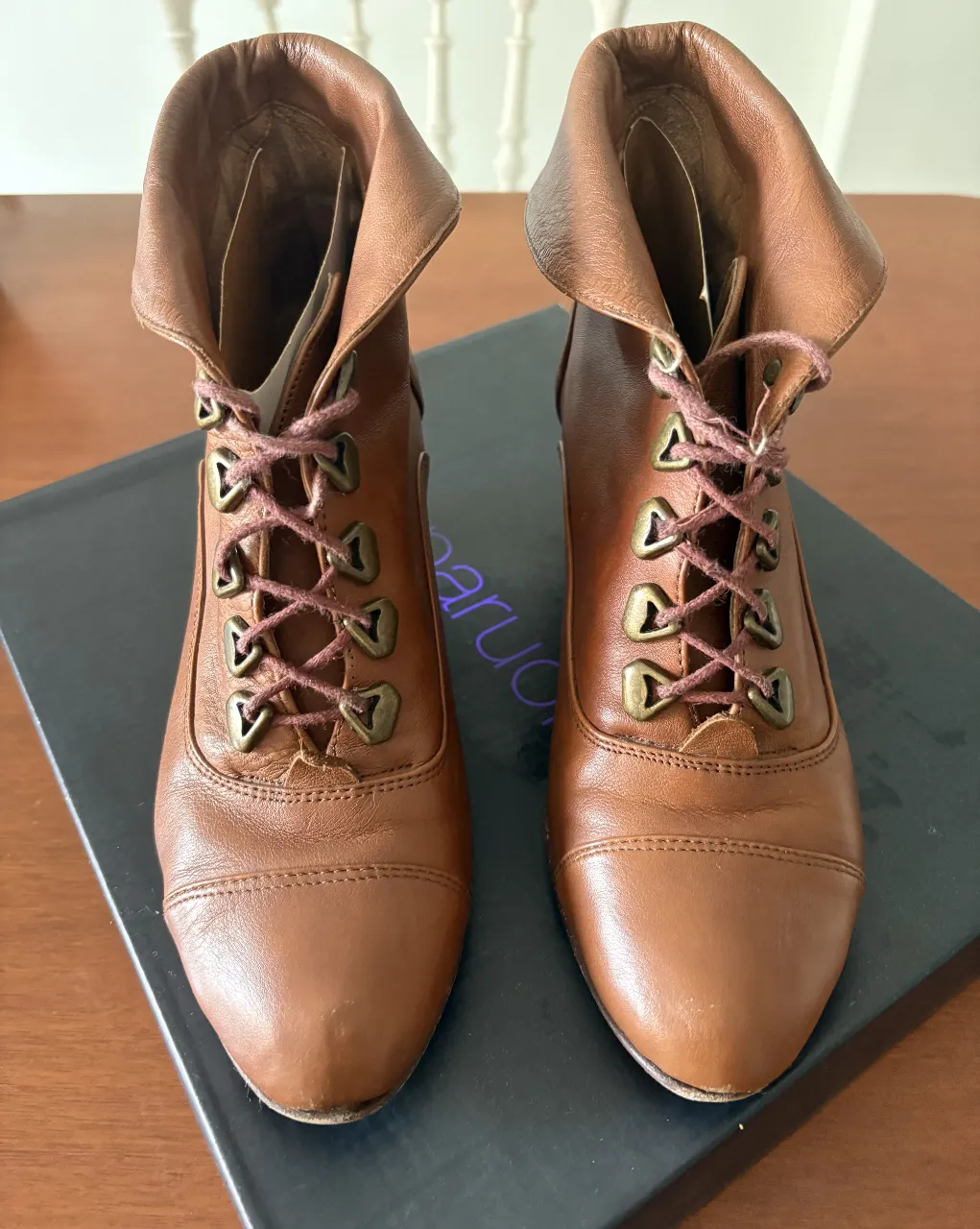 Botines de cuero marrón con cordones y detalles vintage. Ideales para un look elegante y retro.