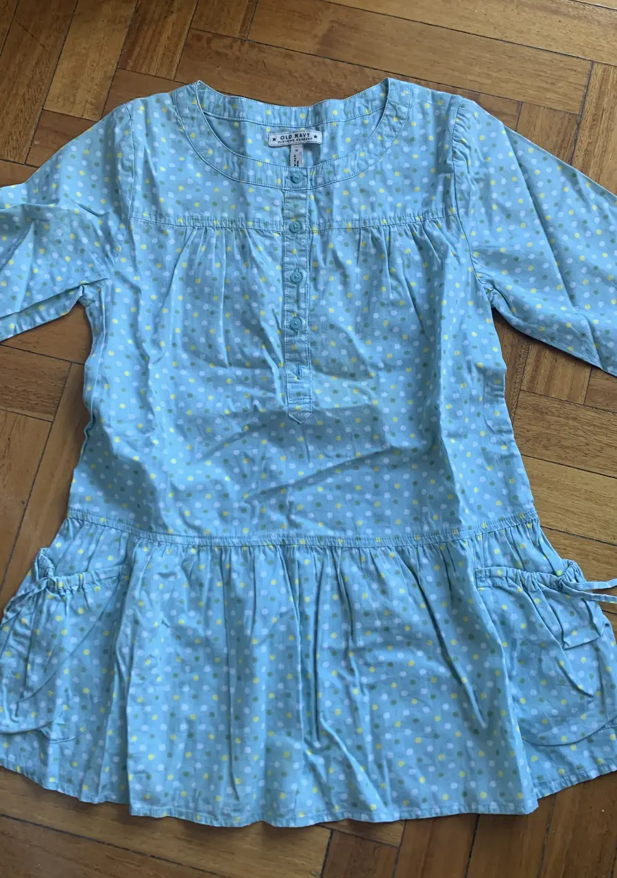 Vestido mini celeste con lunares amarillos y blancos. Mangas 3/4, con botones en el frente y detalles de volados en la falda. Ideal para un look casual y fresco. Para chiquita entre 4-6 años