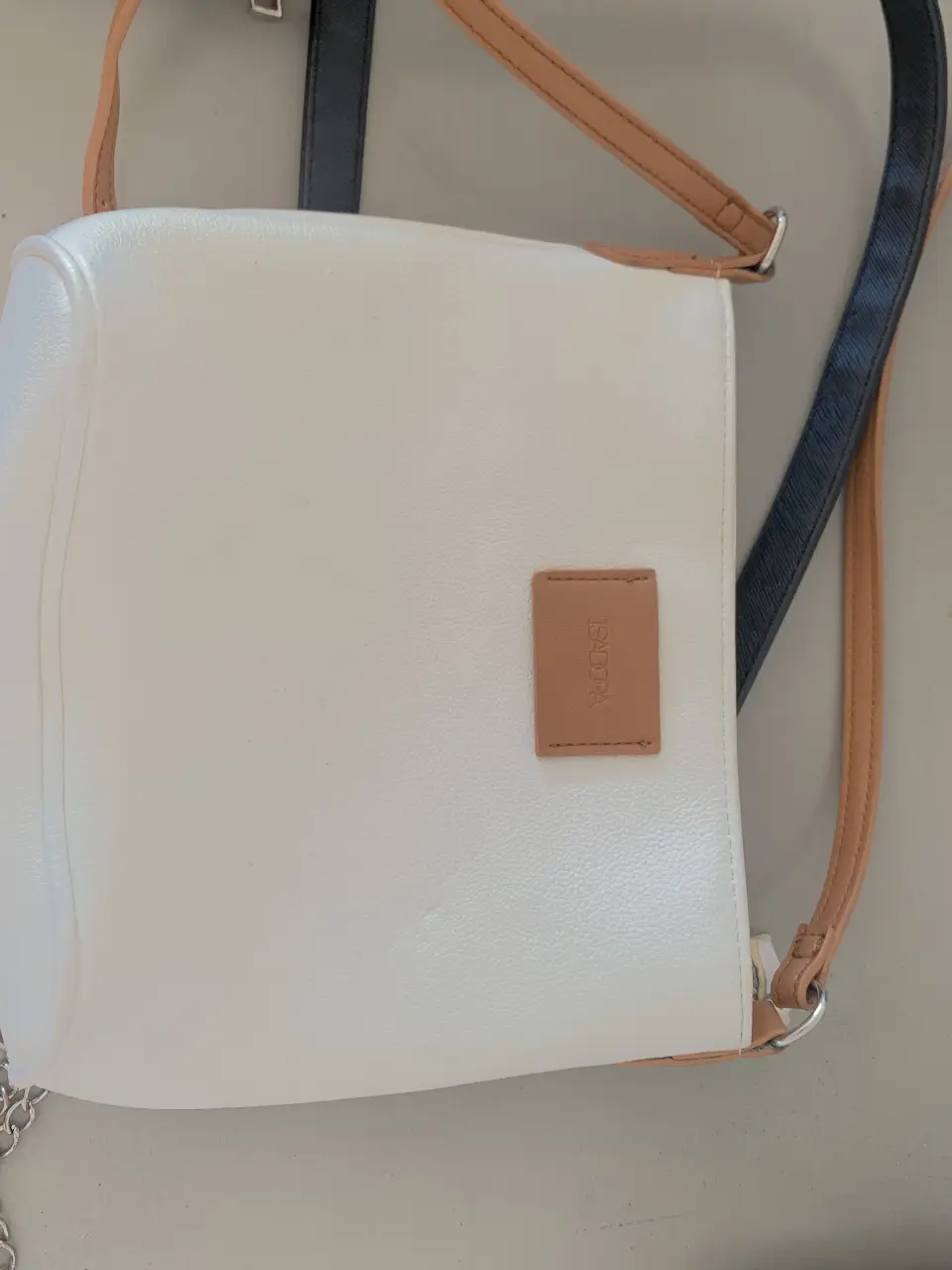 Bandolera blanca con detalles marrones. Ideal para llevar lo esencial con estilo.