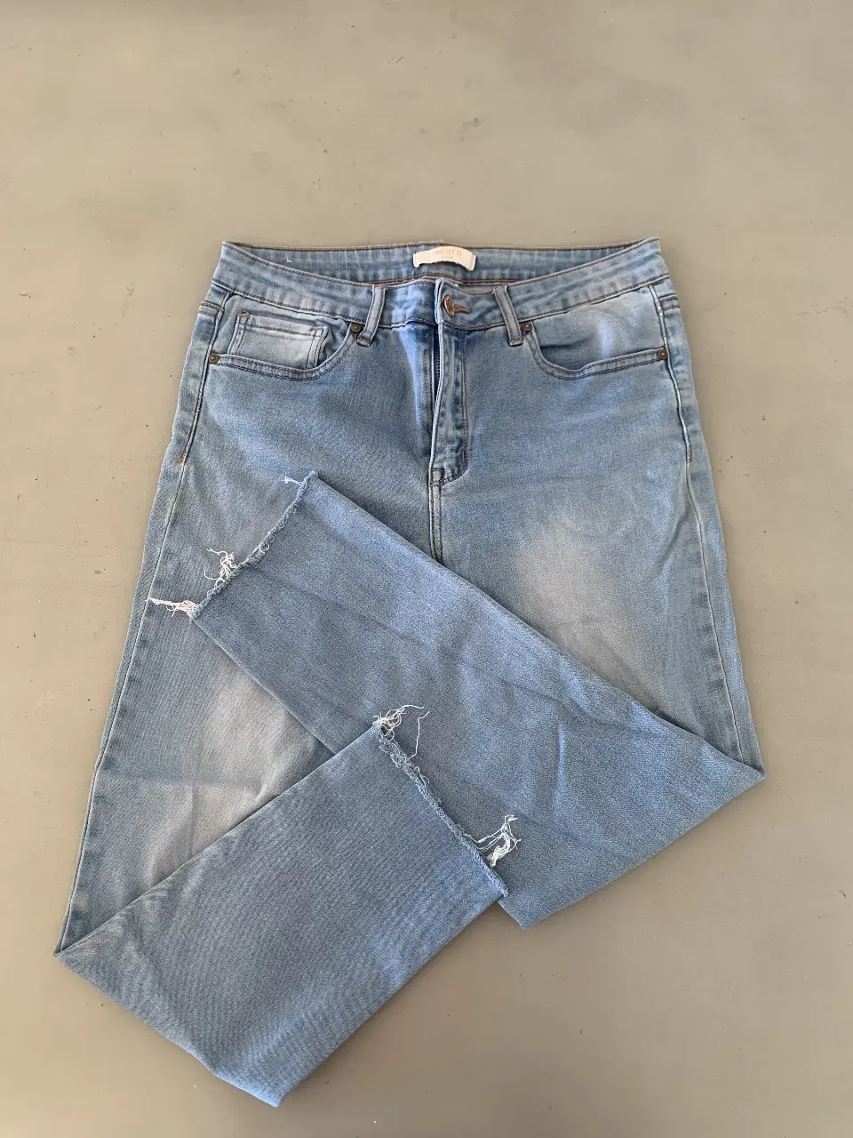 Jeans skinny de mujer, tiro medio, con detalles de roturas en los bajos. Ideal para un look casual y moderno.