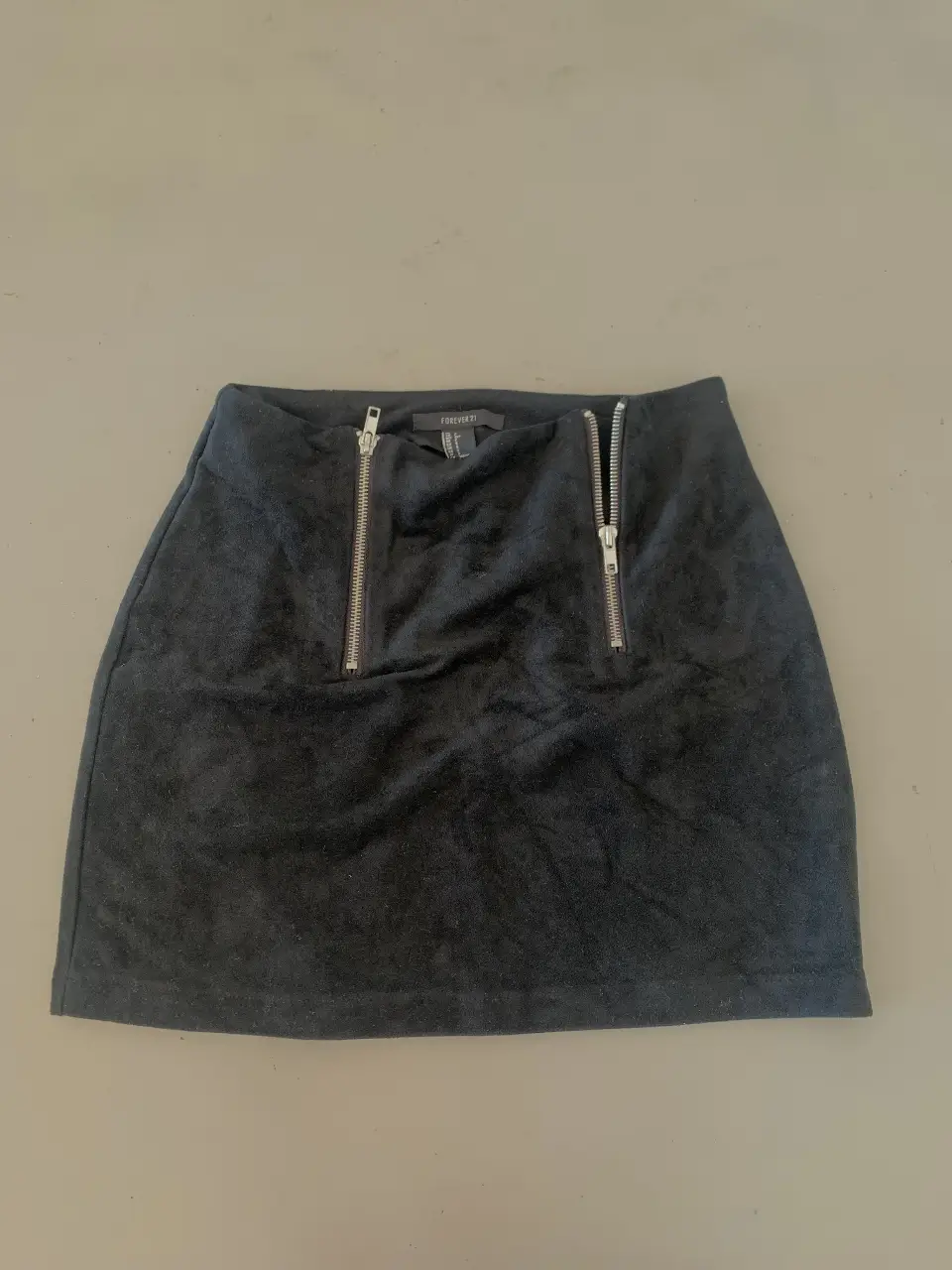 Pollera negra de gamuza con cierre. Ideal para un look moderno y sofisticado.
