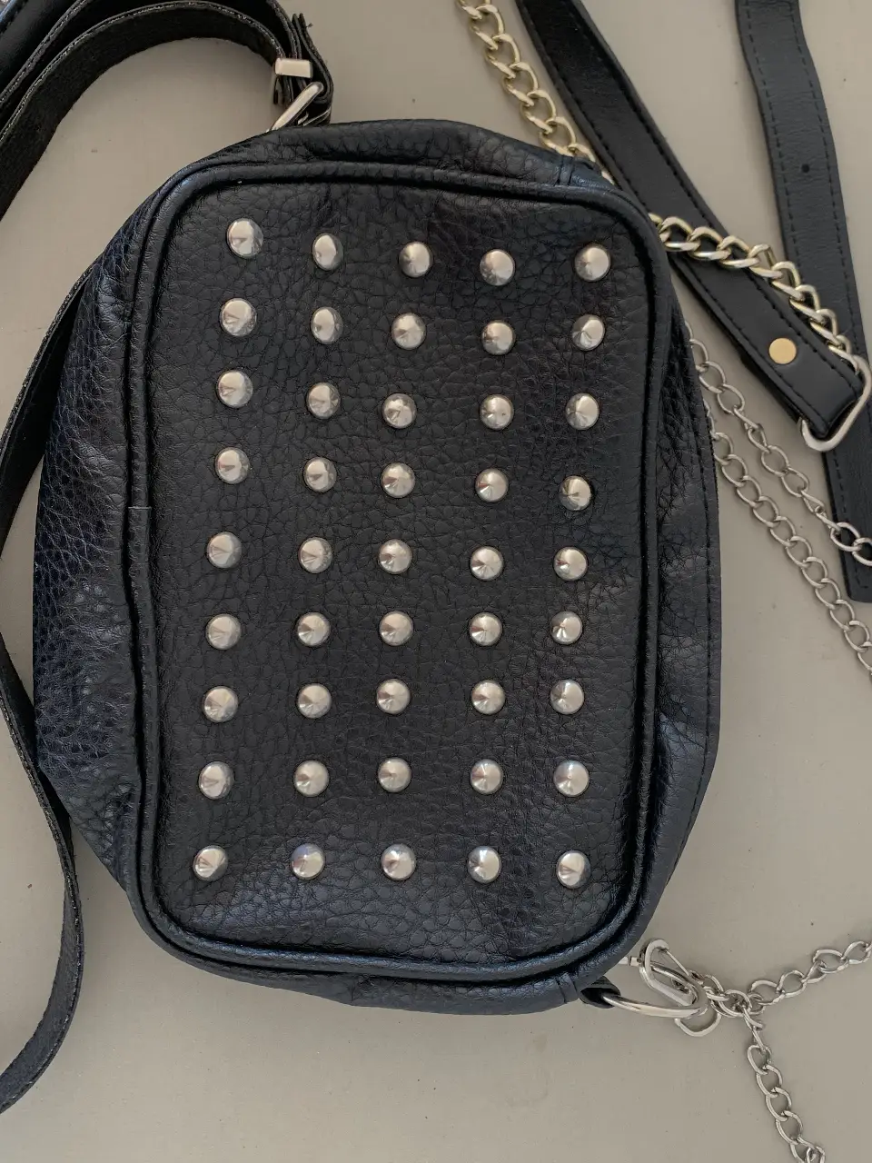 Cartera bandolera negra con tachas plateadas. Ideal para un look rocker o para darle un toque canchero a tu outfit. Perfecta para salidas y eventos.
