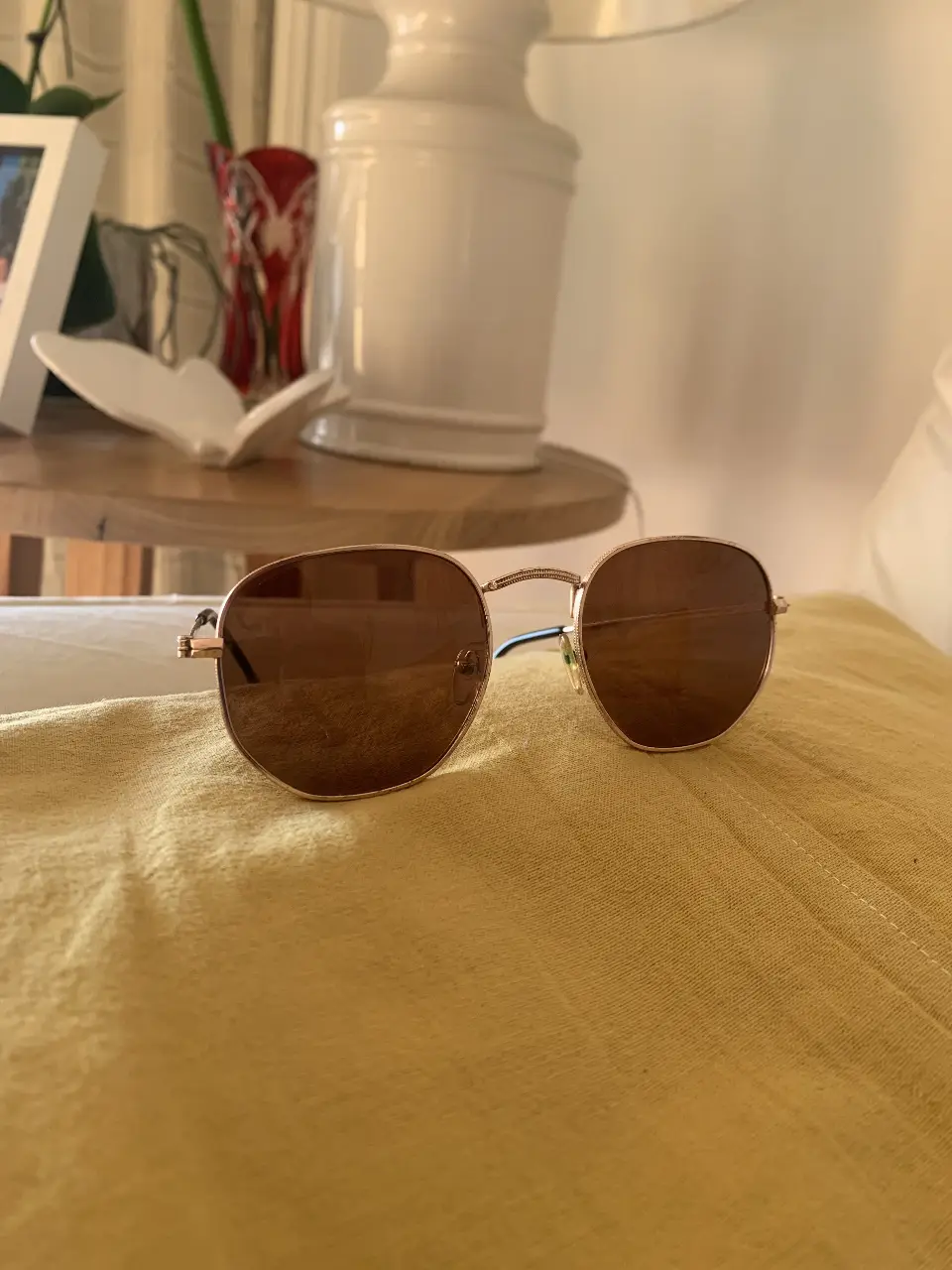 Anteojos de sol con marco dorado y lentes marrones. Un accesorio clásico y versátil para proteger tus ojos con estilo.
