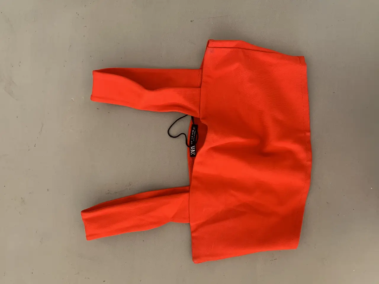 Top naranja de Zara, con breteles anchos y etiqueta de la marca. Ideal para un look moderno y fresco.